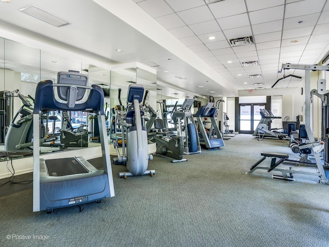 exercise room with carpet floors and a paneled ceiling