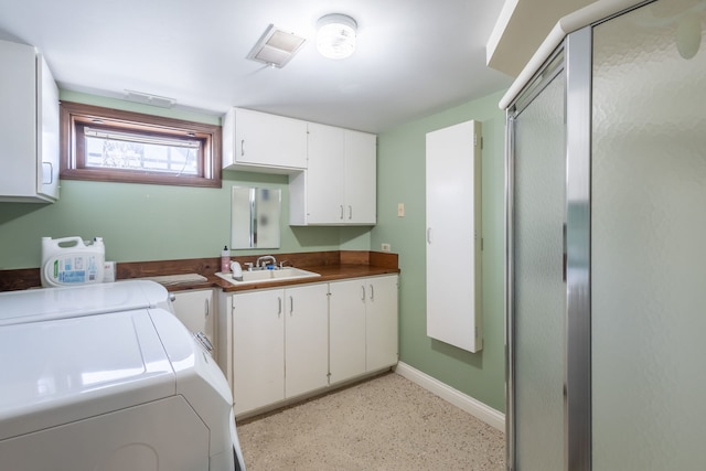 laundry room featuring sink, washing machine and dryer, and cabinets