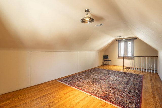 additional living space with lofted ceiling and hardwood / wood-style floors