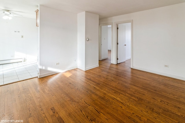 unfurnished room featuring hardwood / wood-style floors, baseboard heating, and ceiling fan