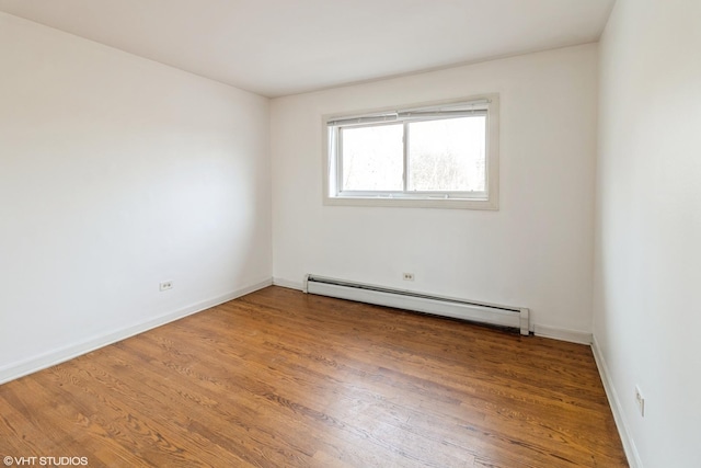 unfurnished room featuring hardwood / wood-style floors and a baseboard radiator