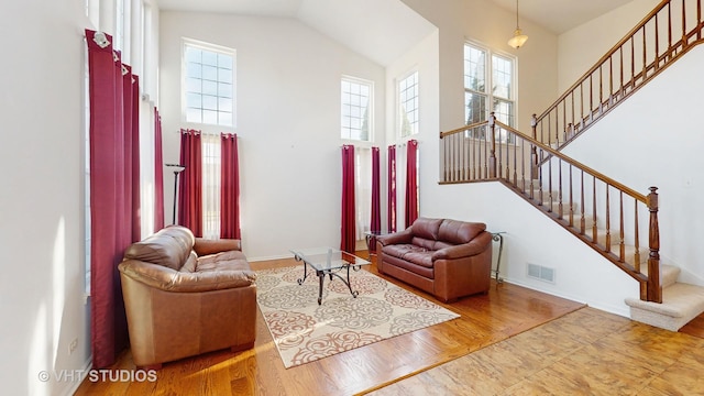 living room featuring hardwood / wood-style flooring and high vaulted ceiling