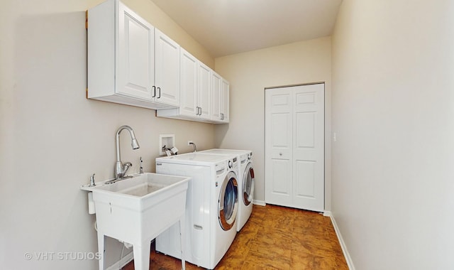 laundry area with sink, washing machine and dryer, and cabinets