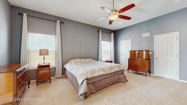 bedroom featuring ceiling fan, light colored carpet, and a closet