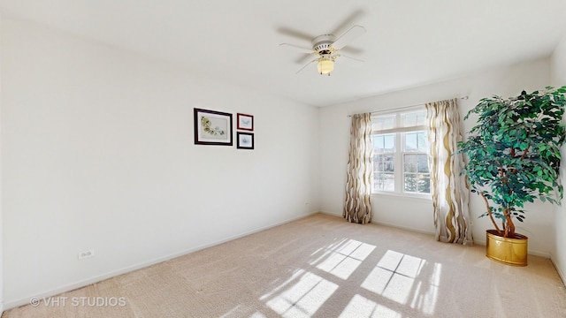 carpeted spare room featuring ceiling fan