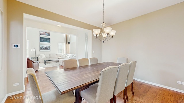 dining space featuring hardwood / wood-style floors and a notable chandelier