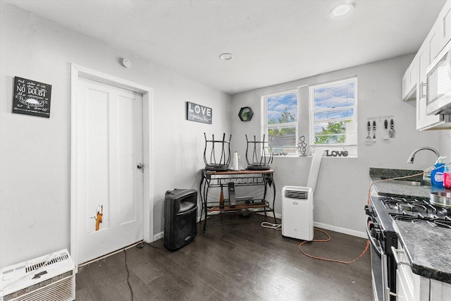 kitchen with white cabinetry, sink, dark wood-type flooring, and stainless steel gas range