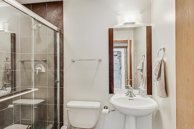 bathroom featuring walk in shower, sink, and toilet