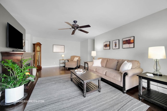 living room with ceiling fan and dark hardwood / wood-style flooring