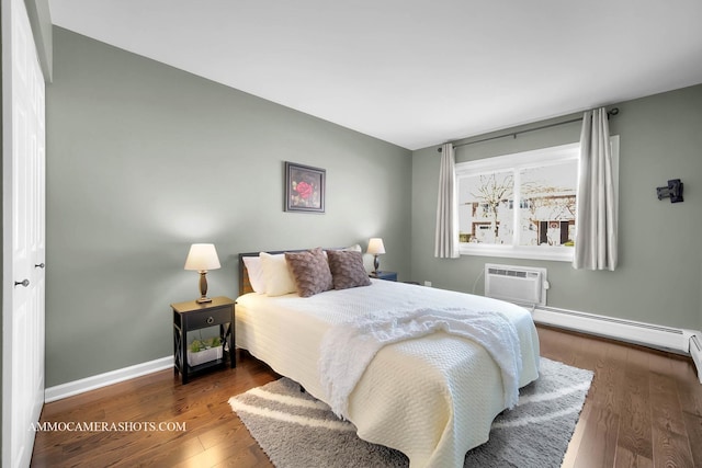 bedroom featuring a baseboard heating unit, a wall unit AC, and dark hardwood / wood-style floors