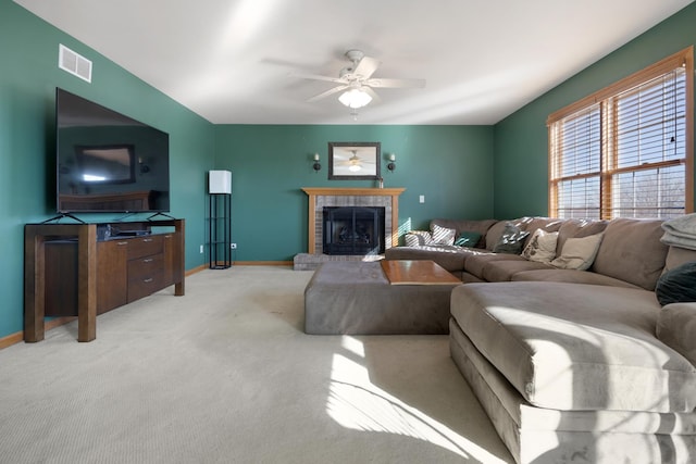 living room with light carpet, a brick fireplace, and ceiling fan