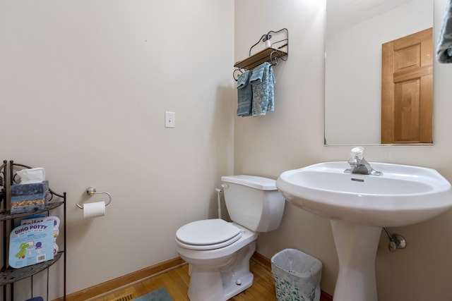 bathroom with hardwood / wood-style floors and toilet