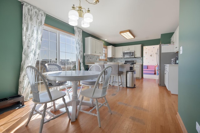 dining area featuring a chandelier and light wood-type flooring