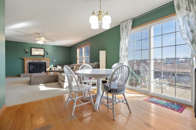 dining room featuring light hardwood / wood-style flooring and ceiling fan with notable chandelier