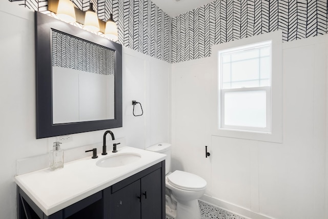 bathroom featuring vanity, toilet, and plenty of natural light