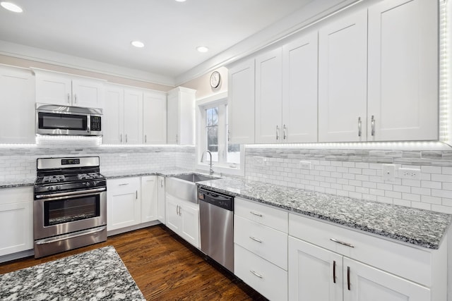 kitchen featuring sink, dark wood-type flooring, tasteful backsplash, white cabinets, and appliances with stainless steel finishes