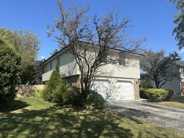 view of side of property featuring a garage and a yard