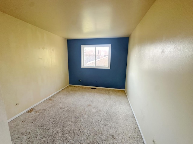 unfurnished room featuring light carpet