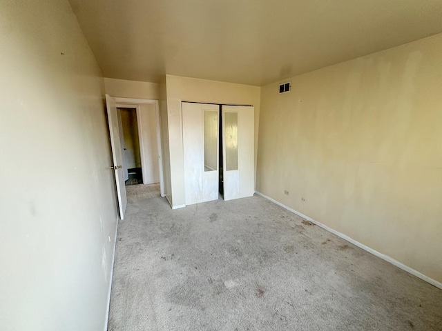 unfurnished bedroom with light carpet and a closet