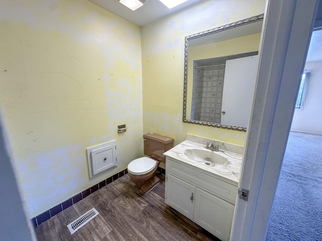 bathroom featuring vanity, hardwood / wood-style flooring, and toilet