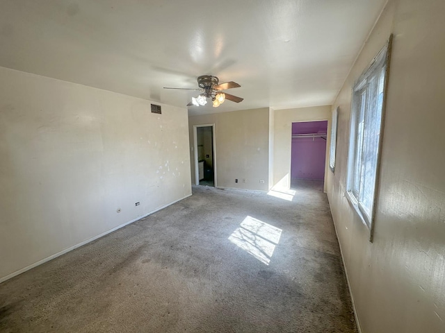 unfurnished bedroom with multiple windows, light carpet, and ceiling fan