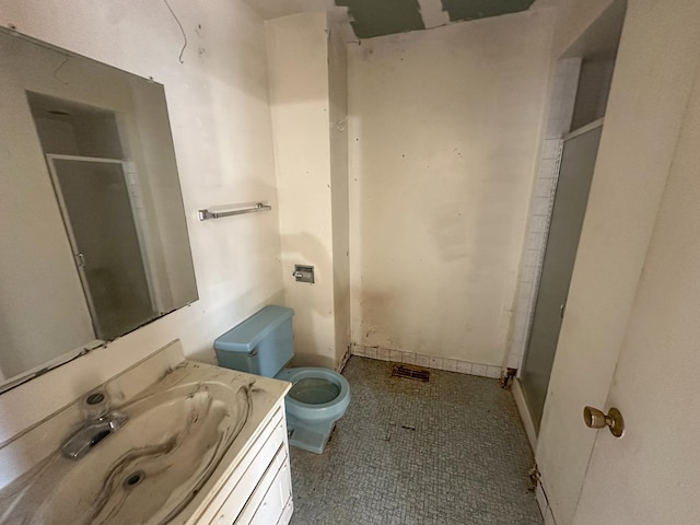 bathroom with tile patterned floors, vanity, toilet, and a shower with shower door