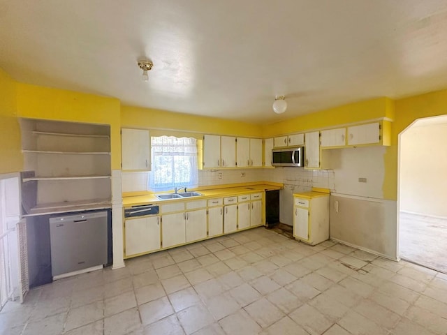 kitchen with cream cabinetry, decorative backsplash, stainless steel appliances, and sink