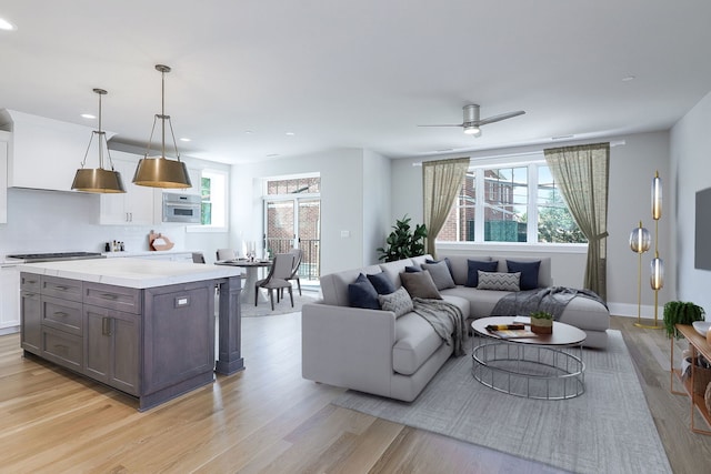 living room featuring ceiling fan and light wood-type flooring