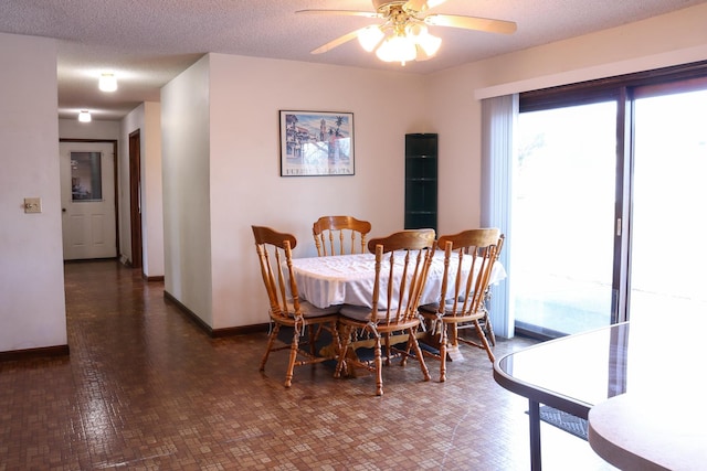 dining area featuring ceiling fan and a textured ceiling