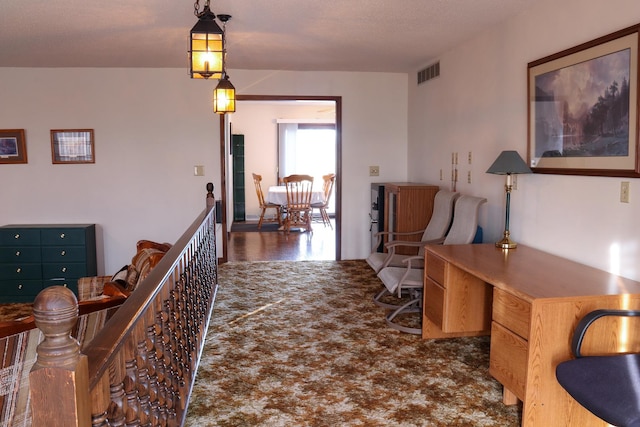 hallway with dark colored carpet