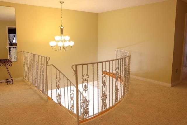 stairway with a chandelier and carpet