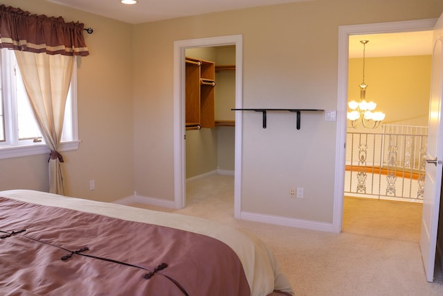 bedroom featuring an inviting chandelier, a walk in closet, carpet floors, and a closet