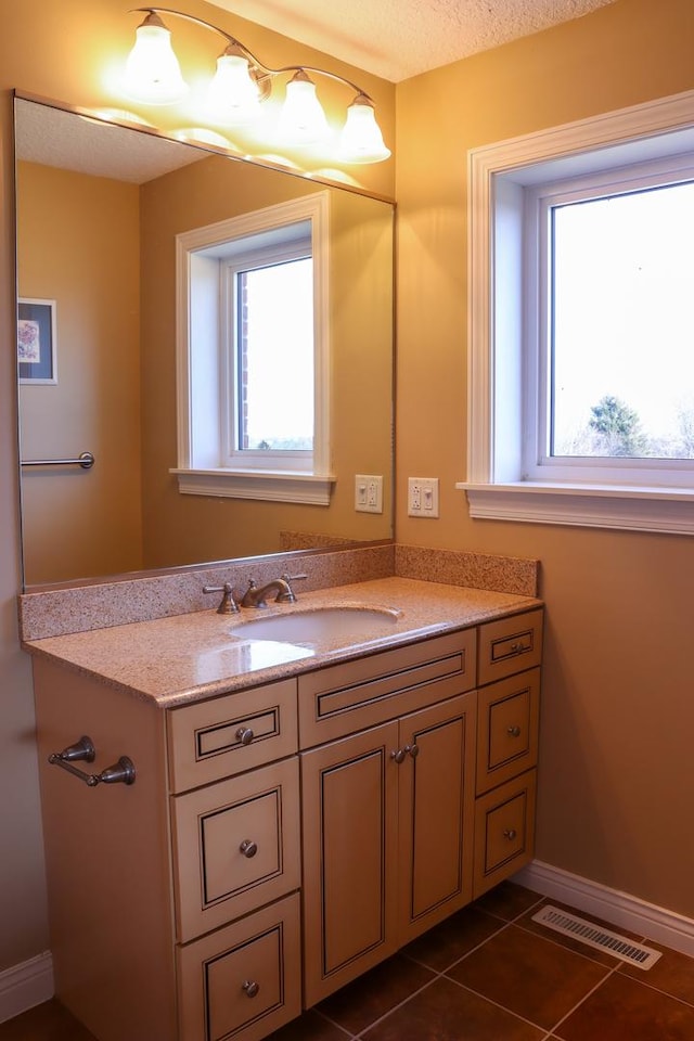 bathroom featuring a textured ceiling, vanity, and tile patterned floors