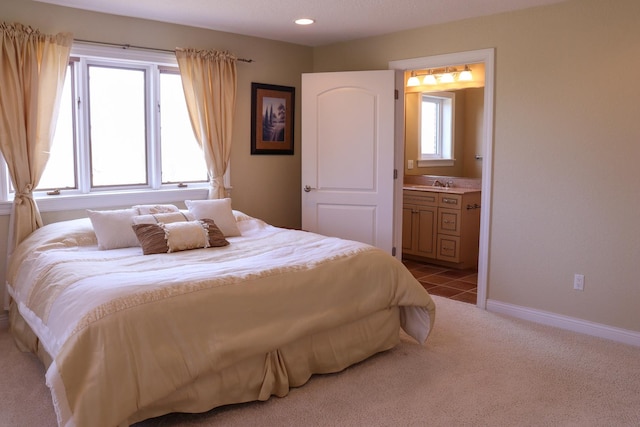 carpeted bedroom featuring sink and connected bathroom