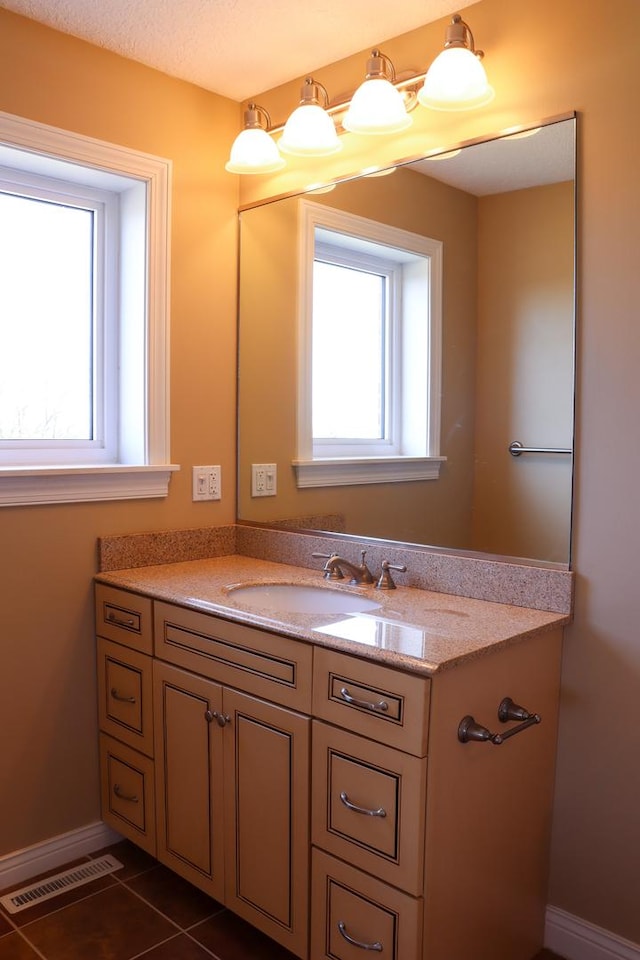 bathroom with tile patterned flooring, vanity, and plenty of natural light