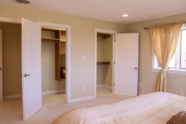 unfurnished bedroom featuring light colored carpet, a spacious closet, and a closet