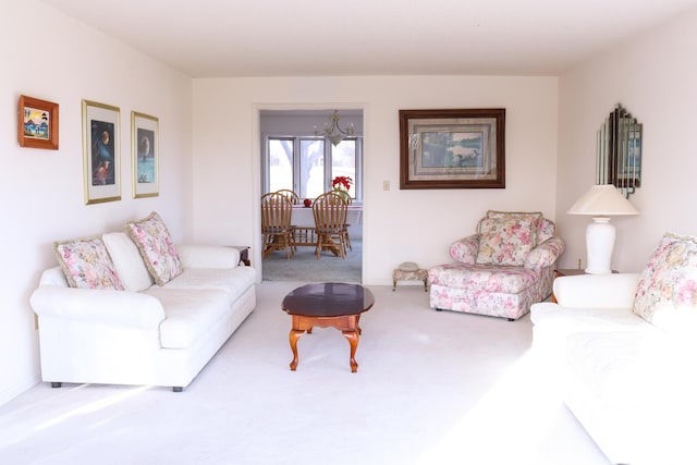 living room with carpet and an inviting chandelier