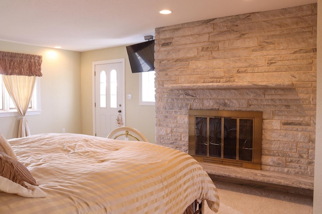 bedroom with carpet flooring and a large fireplace