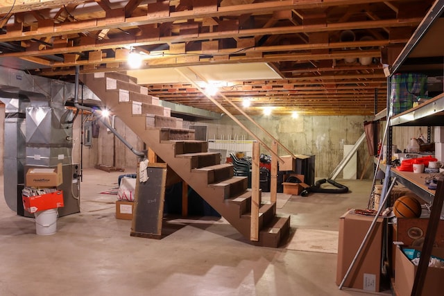 basement featuring electric panel and heating unit