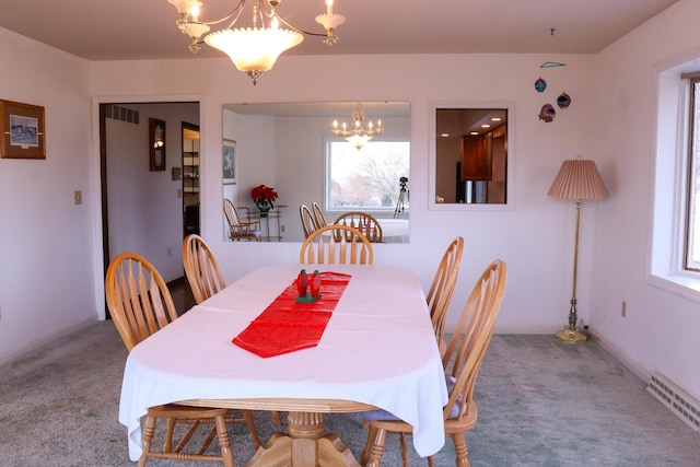 carpeted dining room with a chandelier