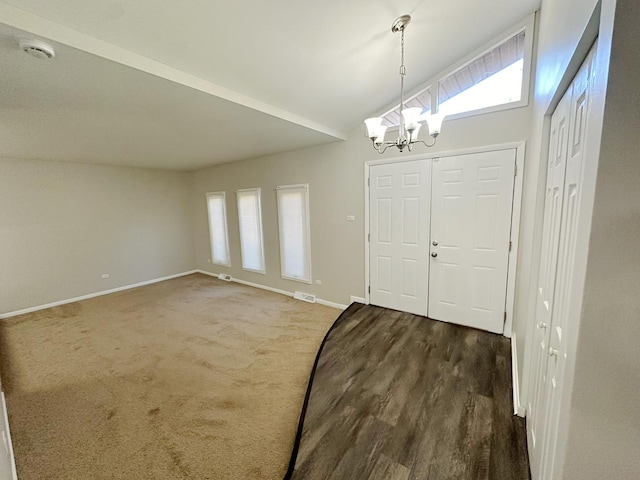 entrance foyer with lofted ceiling, a wealth of natural light, and an inviting chandelier