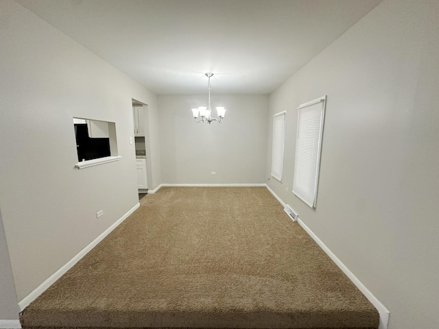 unfurnished dining area with a notable chandelier and carpet floors