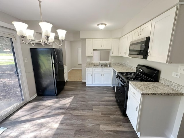 kitchen with sink, an inviting chandelier, pendant lighting, white cabinets, and black appliances