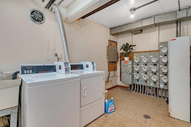 laundry area with washing machine and dryer, electric panel, and sink