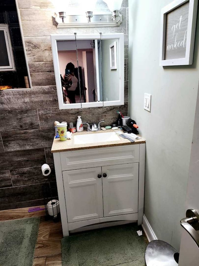 bathroom featuring vanity and wood walls