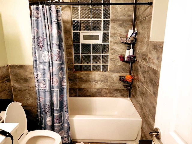 bathroom featuring toilet, tile walls, and shower / tub combo with curtain