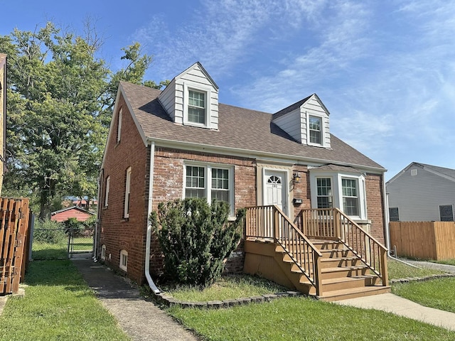 cape cod home with a front lawn