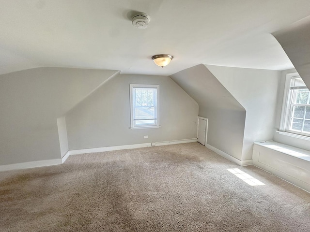 additional living space with light carpet, plenty of natural light, and lofted ceiling