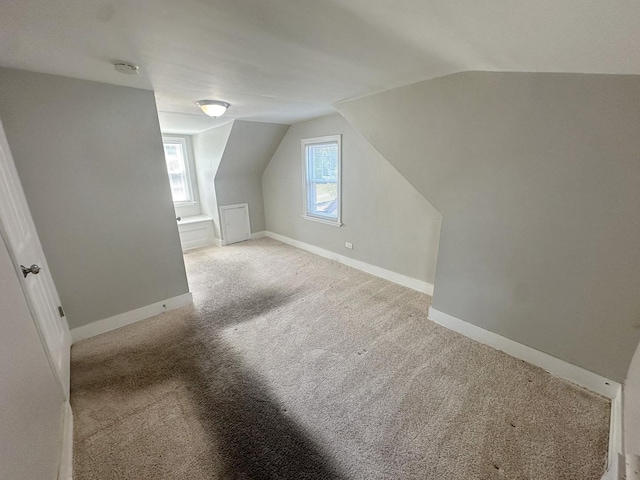 bonus room with light colored carpet and lofted ceiling