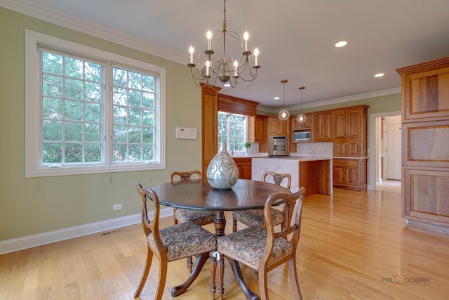 dining space featuring light hardwood / wood-style flooring, an inviting chandelier, and crown molding